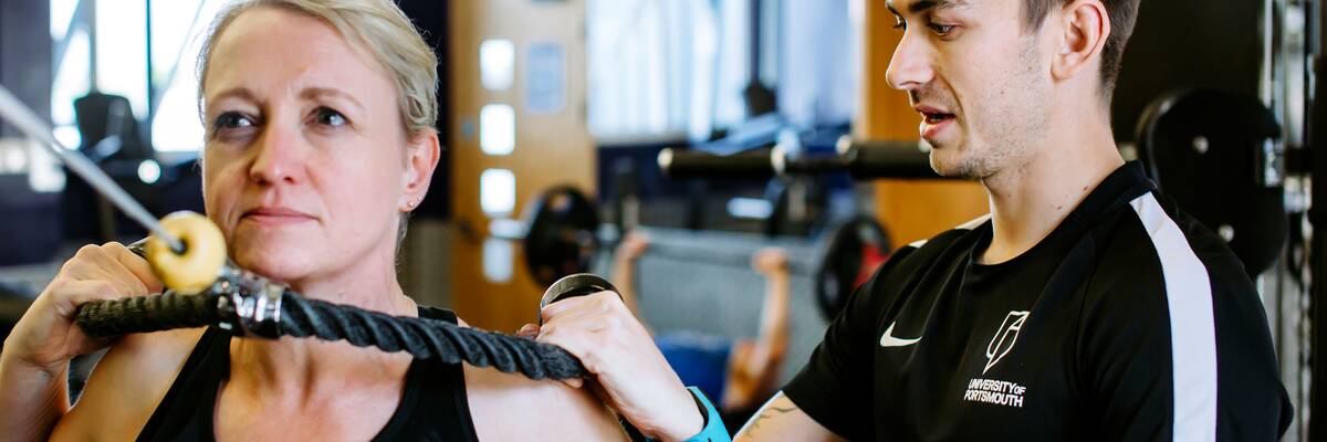 Man training woman while working for UOP Sport